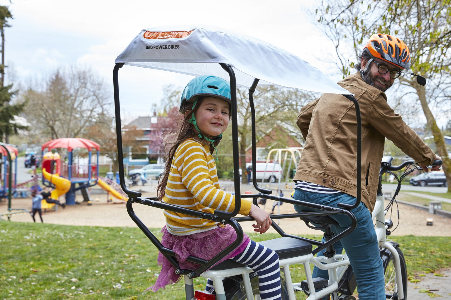 Man with child on bike with sun cover